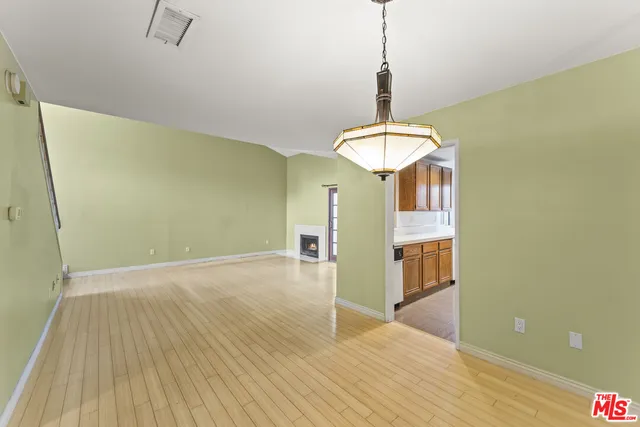 a view of a room with wooden floor and a chandelier