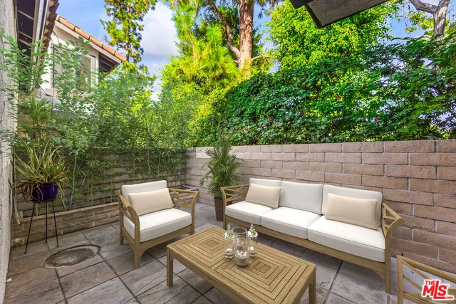 a view of a patio with couches table and chairs and potted plants