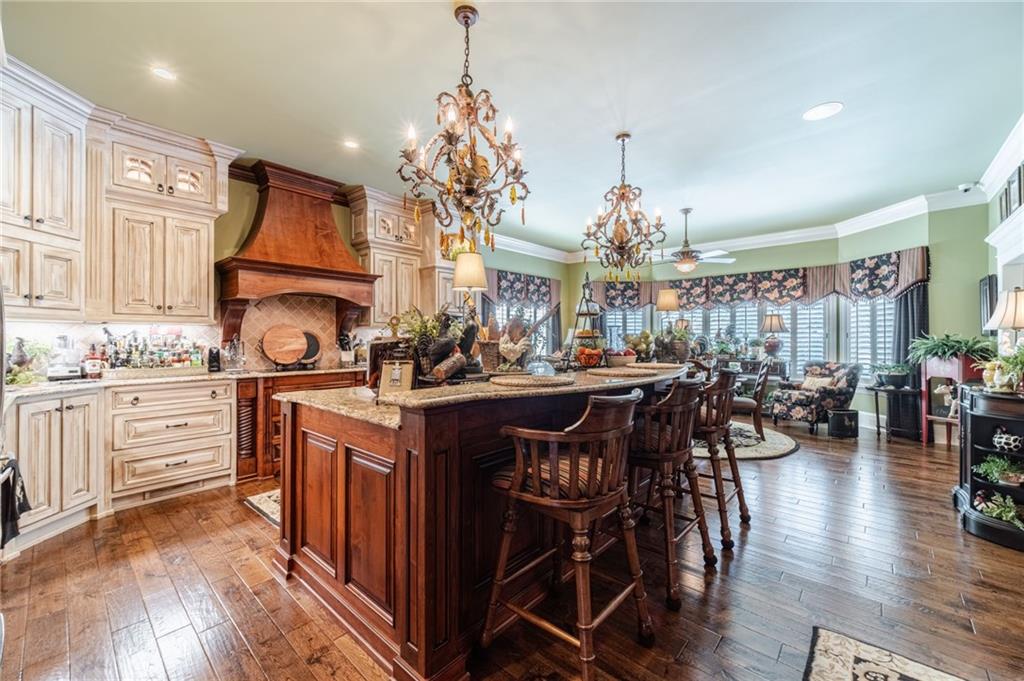 1600 Beagle Run Monroe, GA 30656 - Photo 26 of 103 a kitchen with stainless steel appliances granite countertop a stove top oven a refrigerator a dining table and chairs with wooden floor