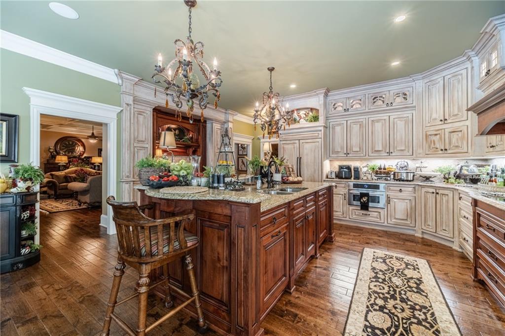 1600 Beagle Run Monroe, GA 30656 - Photo 30 of 103 a kitchen with stainless steel appliances granite countertop a stove top oven a refrigerator a sink dishwasher and a dining table with wooden floor