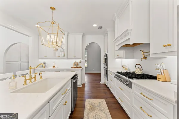 a kitchen with kitchen island stainless steel appliances a sink stove and cabinets