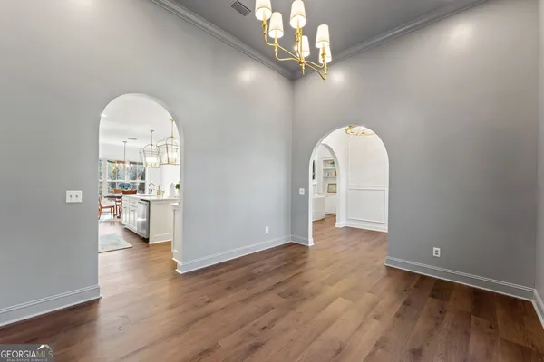 a view of a livingroom with wooden floor and a kitchen