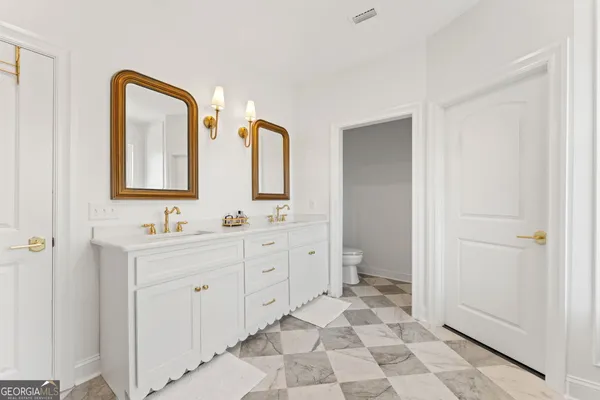 a spacious bathroom with 2 sink and a mirror