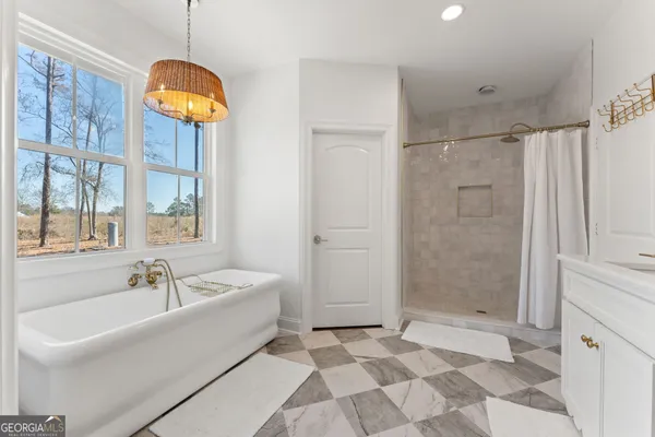 a bathroom with a tub a sink and a shower