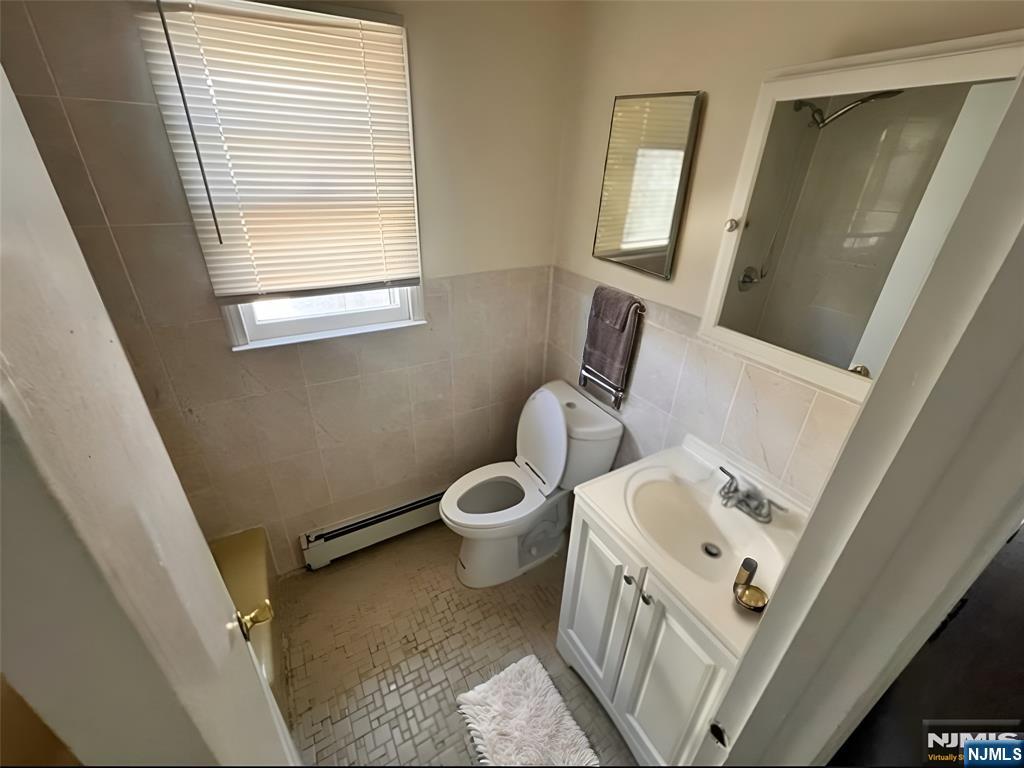 316 John Street, Unit 2 Harrison, NJ 07029 - Photo 7 of 7 a bathroom with a toilet sink and mirror