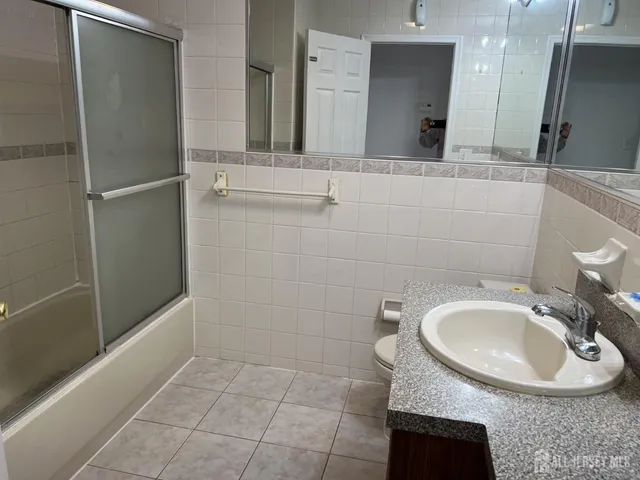 a bathroom with a sink a toilet and a mirror