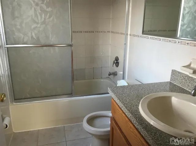 a bathroom with a granite countertop bathtub and toilet