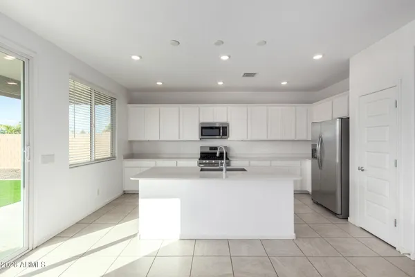 a kitchen with stainless steel appliances granite countertop a refrigerator sink and stove