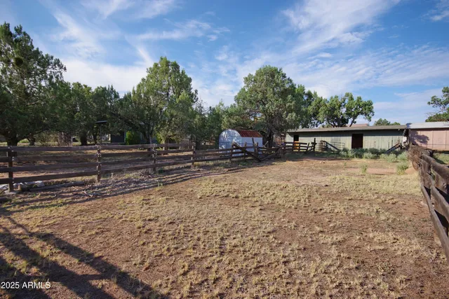 a view of a yard with wooden fence