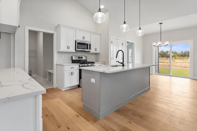 a large kitchen with stainless steel appliances granite countertop a stove a sink and a refrigerator