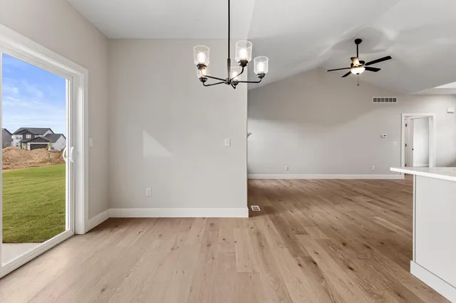 an empty room with fan and windows