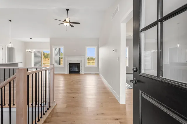 a view of a hallway with wooden floor and a kitchen