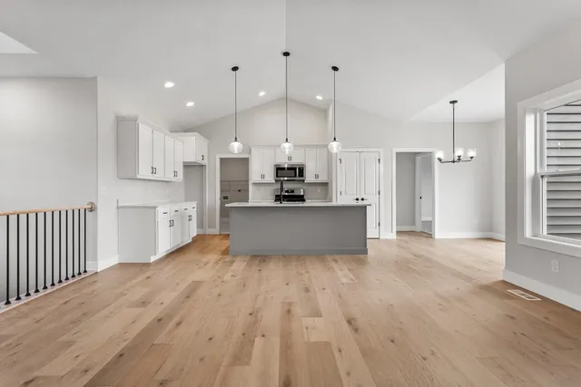 a large kitchen with cabinets wooden floor stainless steel appliances and a fireplace