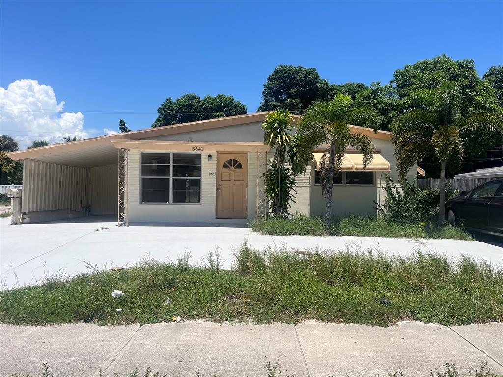 5641 Sheridan Street Hollywood, FL 33021 - Photo 3 of 13 a front view of a house with a yard and garage