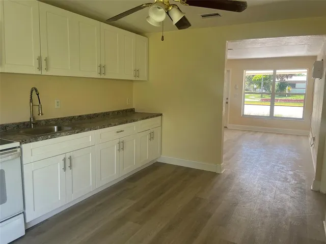 a kitchen with granite countertop white cabinets and white appliances