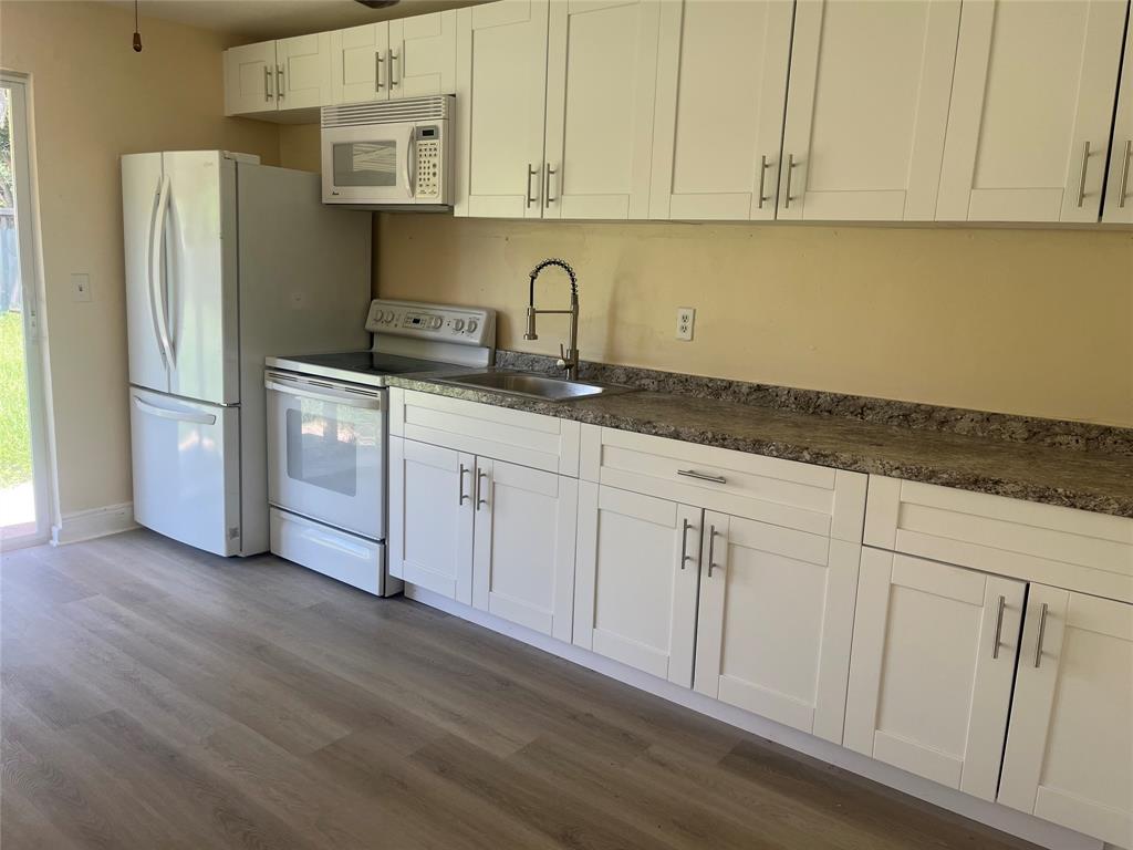 5641 Sheridan Street Hollywood, FL 33021 - Photo 10 of 13 a kitchen with stainless steel appliances granite countertop a refrigerator sink and cabinets