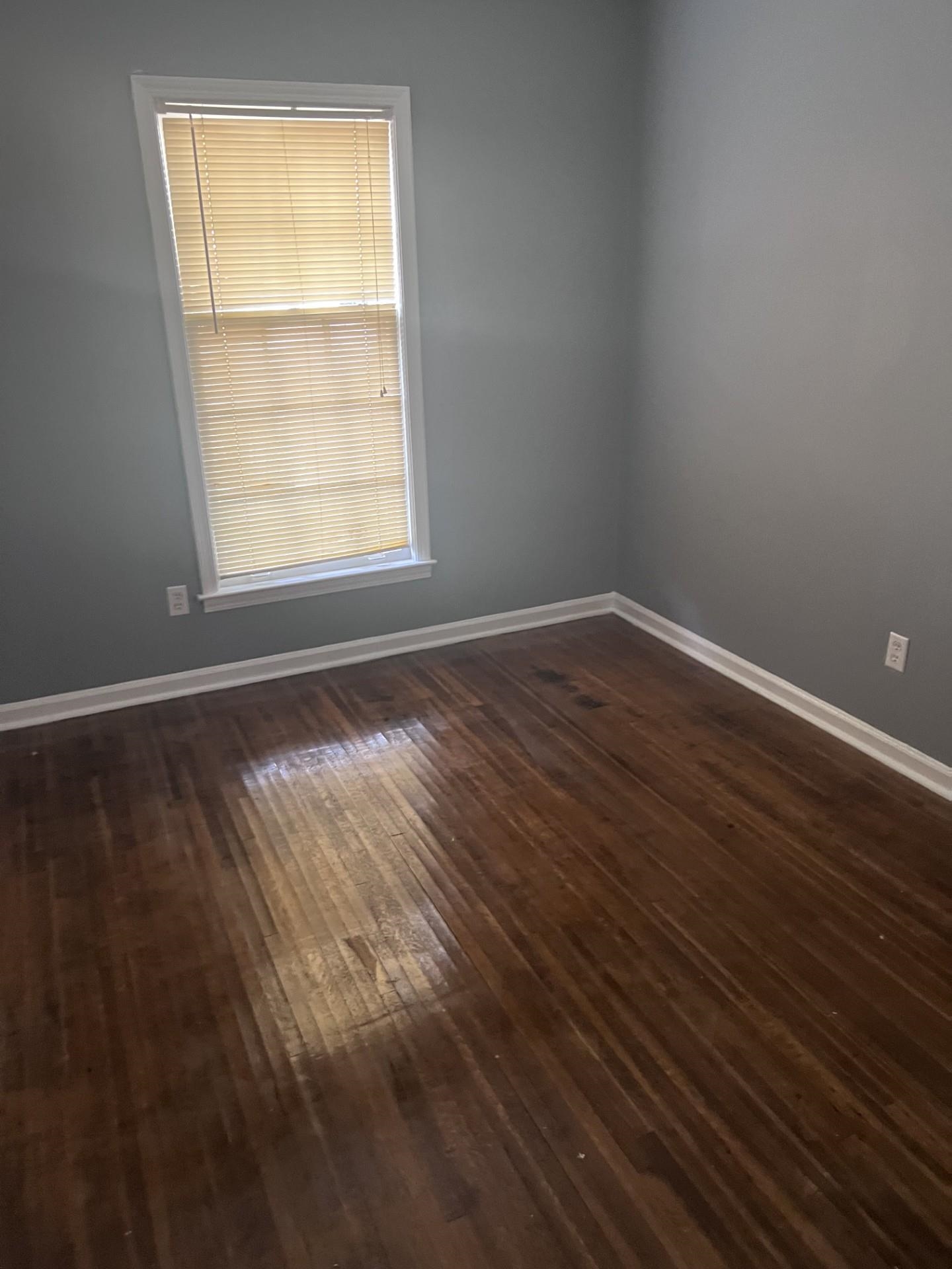 3553 Rhodes Avenue Memphis, TN 38111 - Photo 9 of 14 an empty room with wooden floor and windows