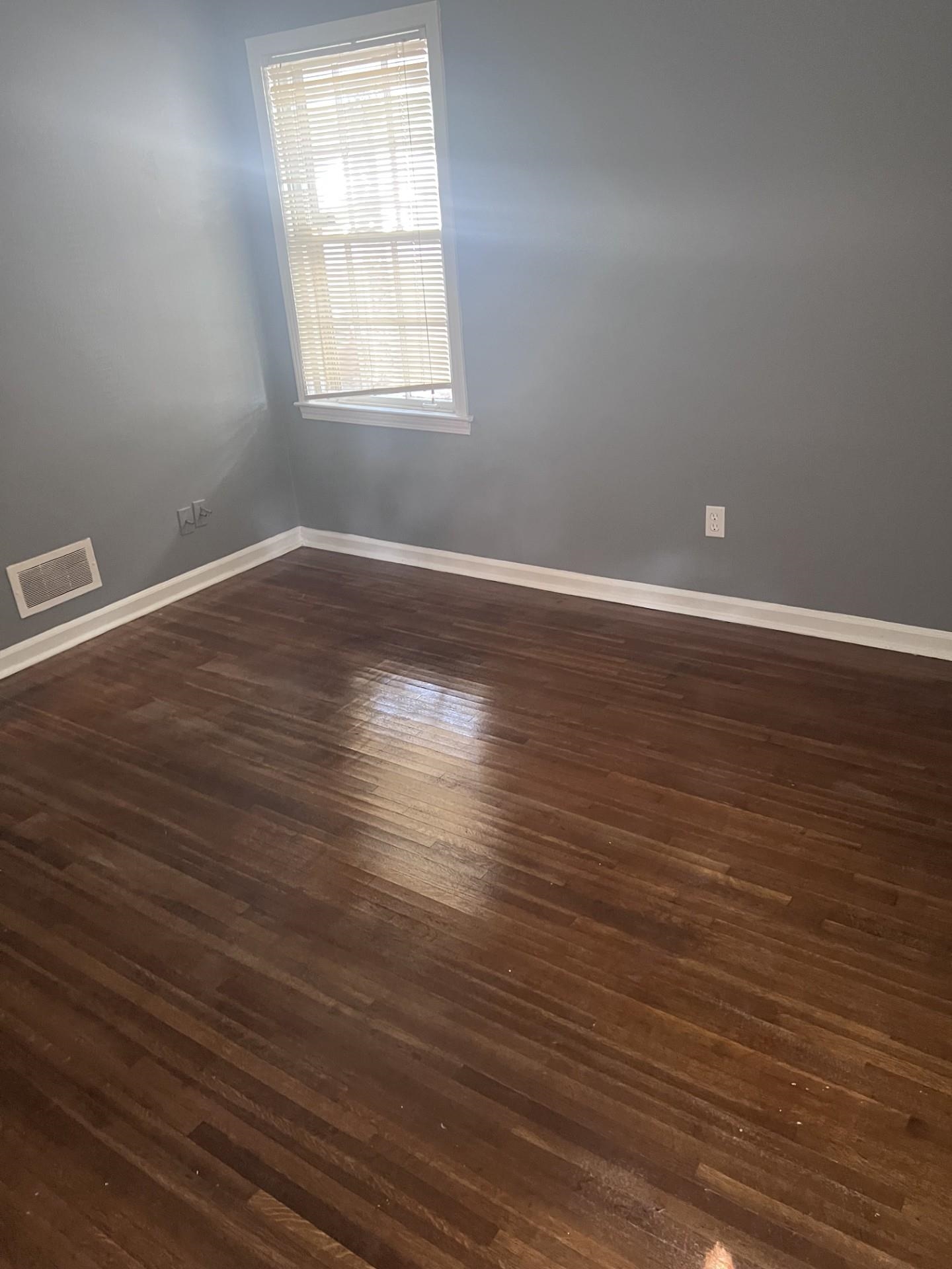 3553 Rhodes Avenue Memphis, TN 38111 - Photo 10 of 14 an empty room with wooden floor and windows