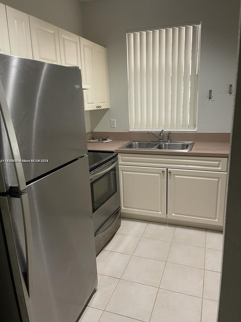 6912 West Sample Road, Unit 6912 Pompano Beach, FL 33063 - Photo 12 of 27 a kitchen with stainless steel appliances granite countertop a refrigerator sink and cabinets