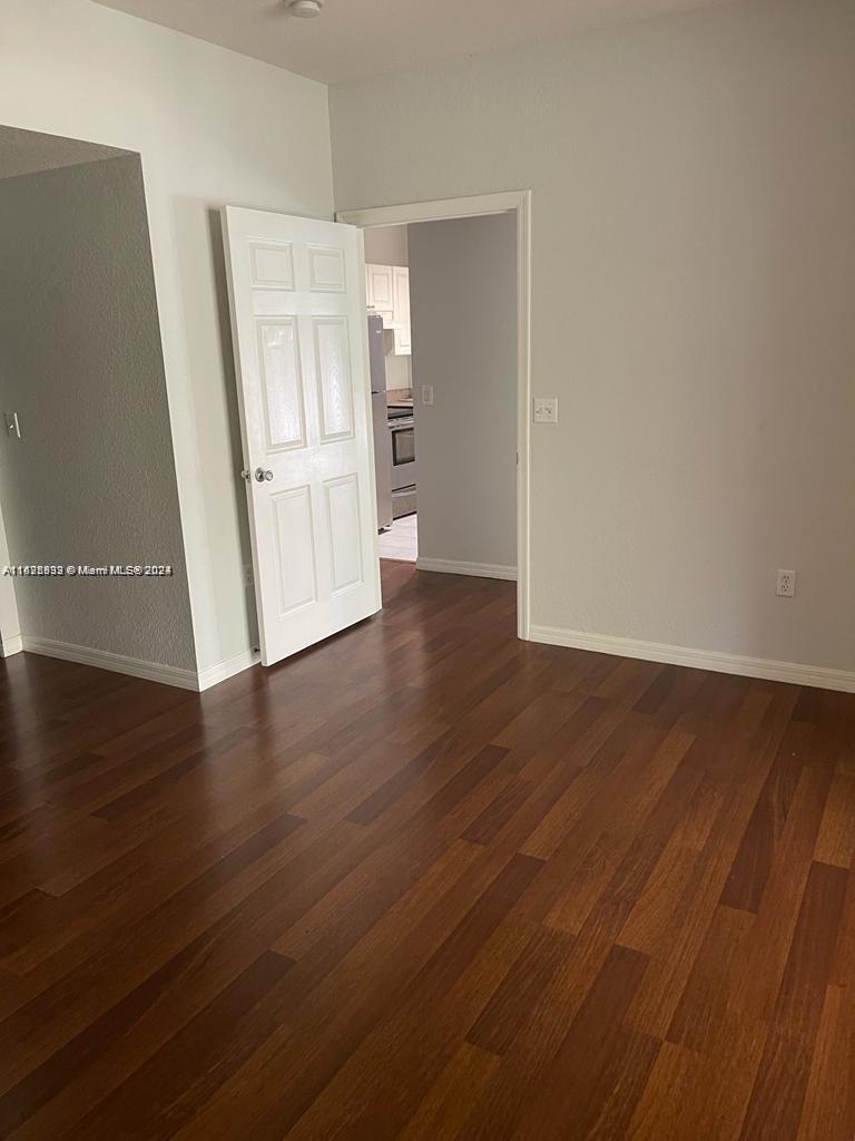 6912 West Sample Road, Unit 6912 Pompano Beach, FL 33063 - Photo 14 of 27 an empty room with wooden floor