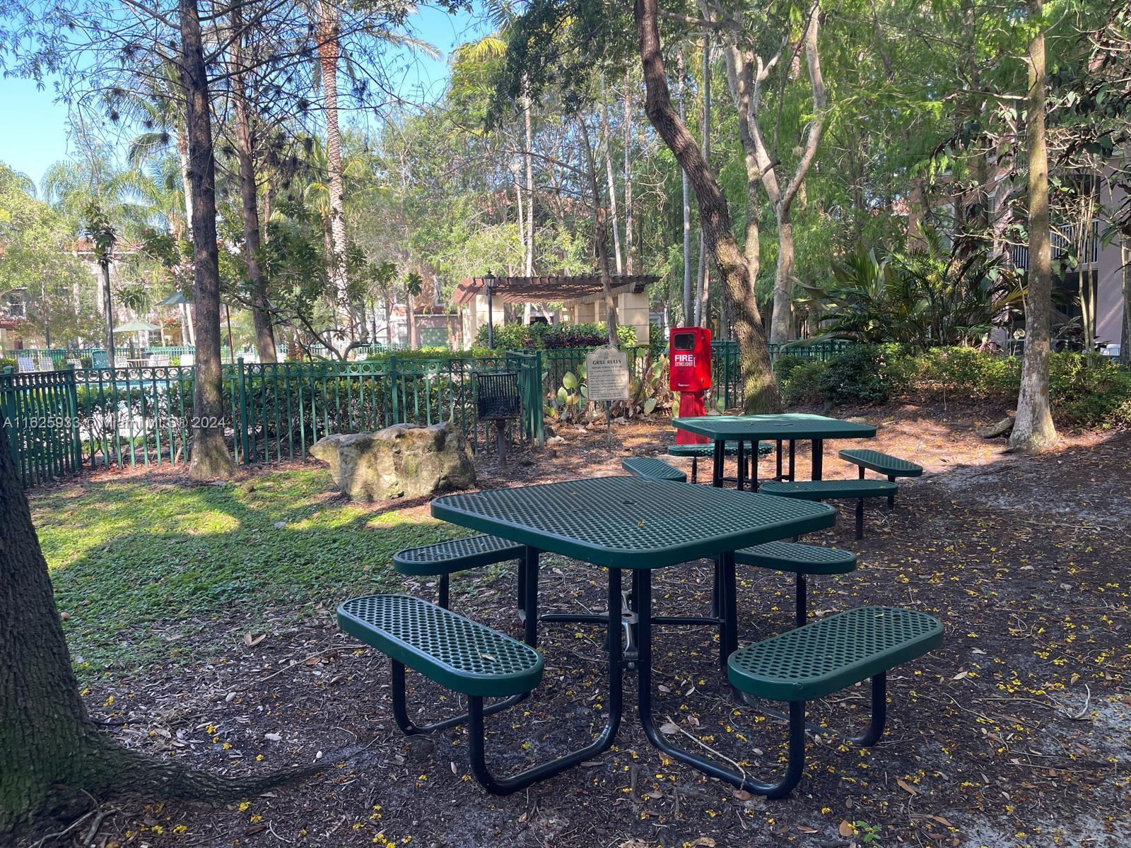 6912 West Sample Road, Unit 6912 Pompano Beach, FL 33063 - Photo 17 of 27 a backyard of a house with barbeque oven table and chairs