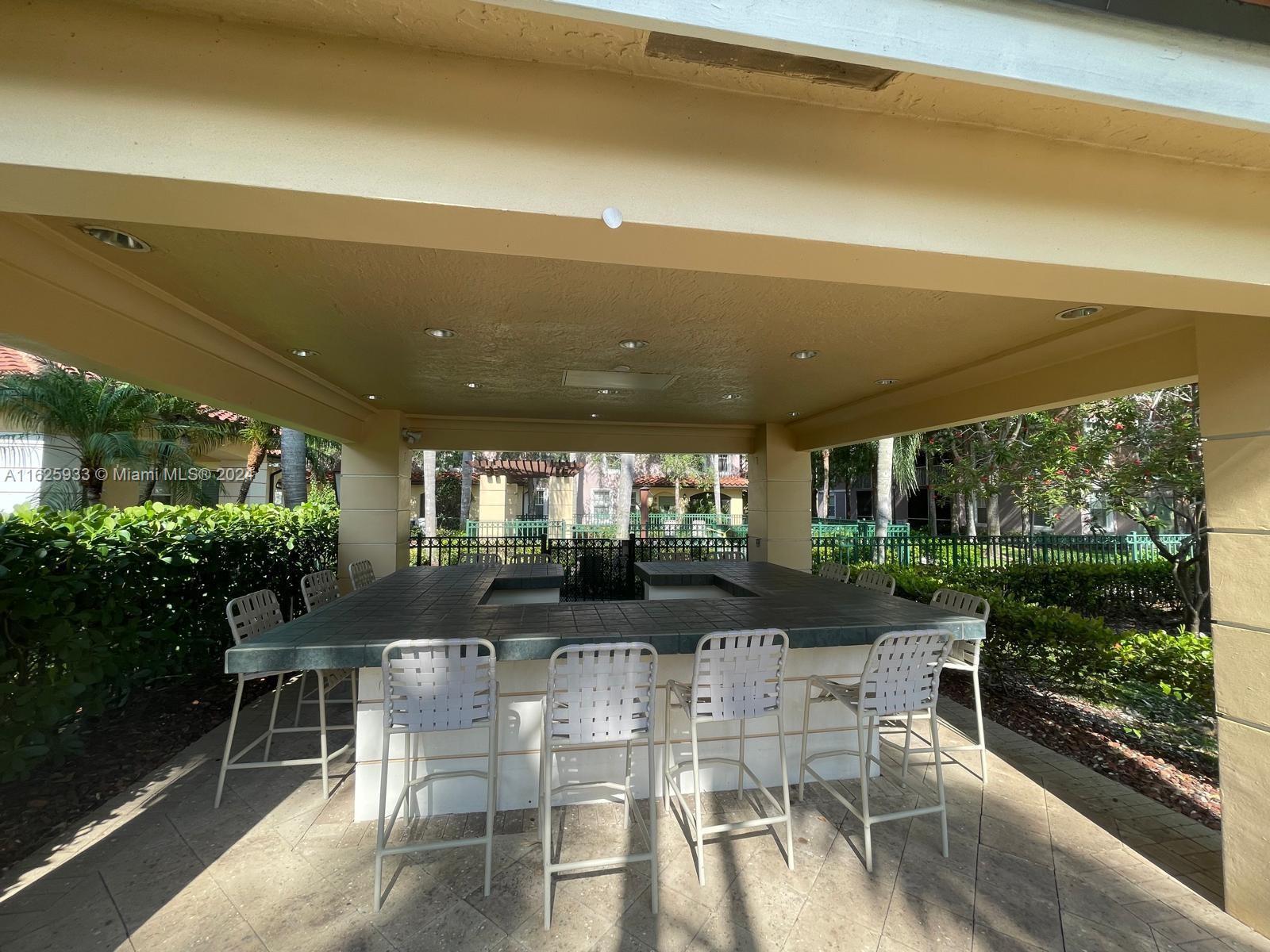 6912 West Sample Road, Unit 6912 Pompano Beach, FL 33063 - Photo 19 of 27 a dining room with furniture and a garden