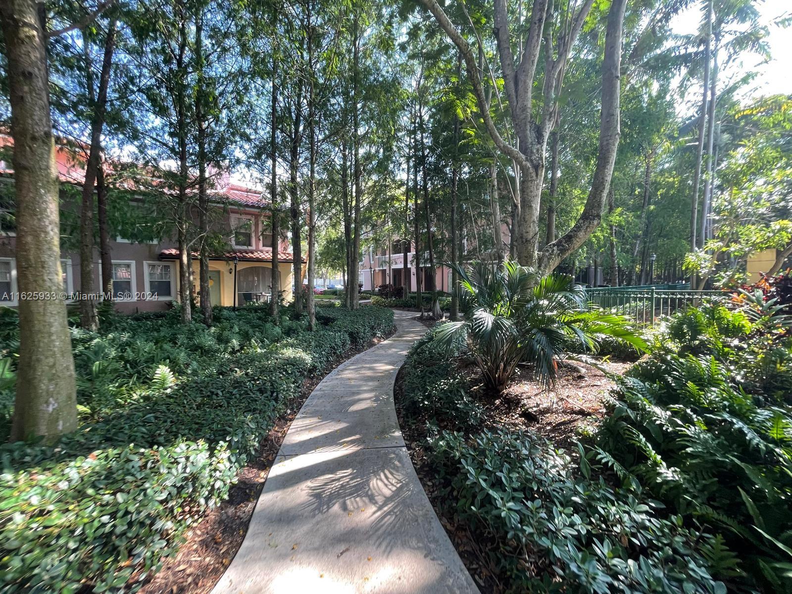 6912 West Sample Road, Unit 6912 Pompano Beach, FL 33063 - Photo 24 of 27 a view of a garden with large trees