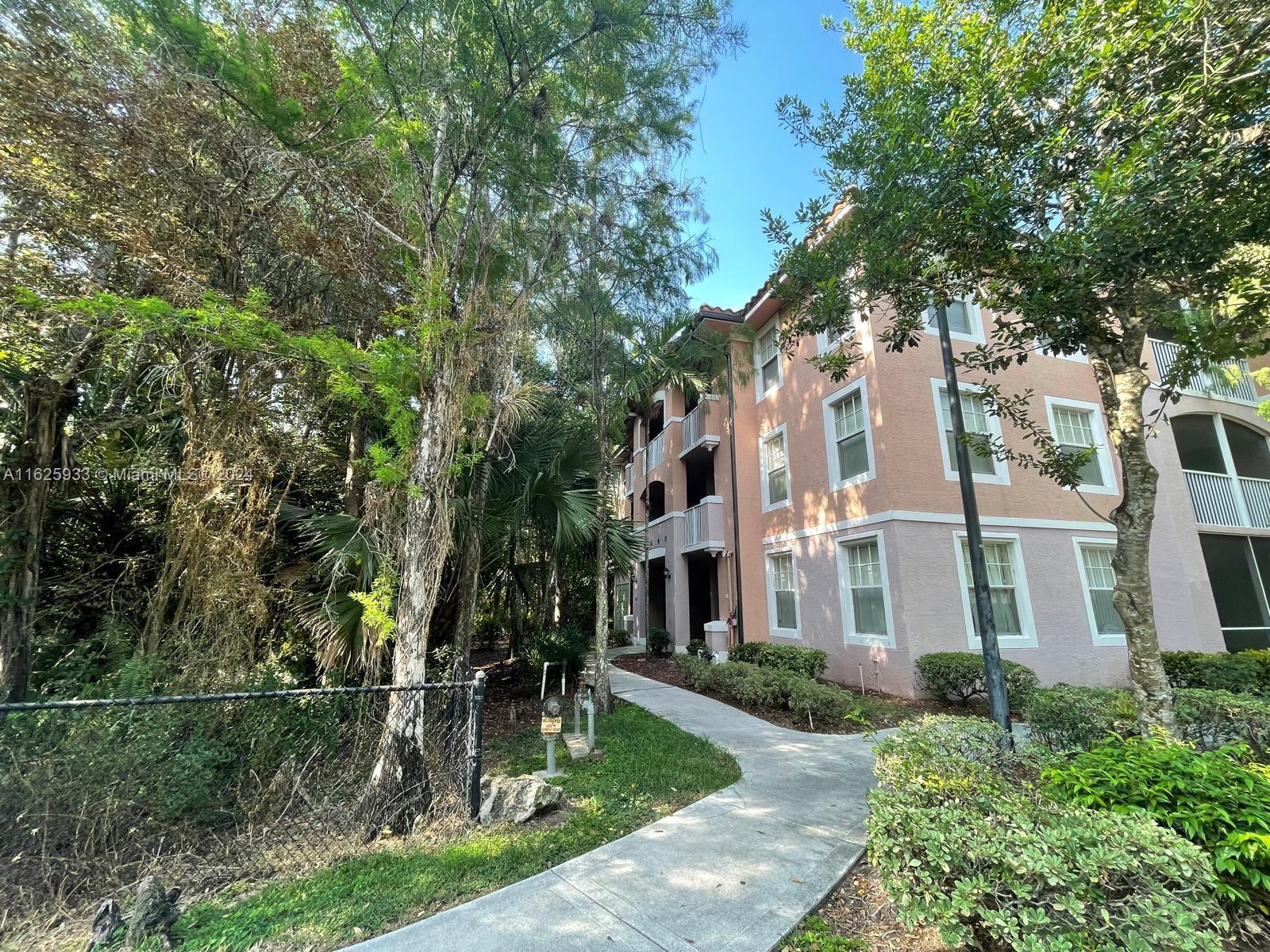 6912 West Sample Road, Unit 6912 Pompano Beach, FL 33063 - Photo 25 of 27 a front view of a house with a yard