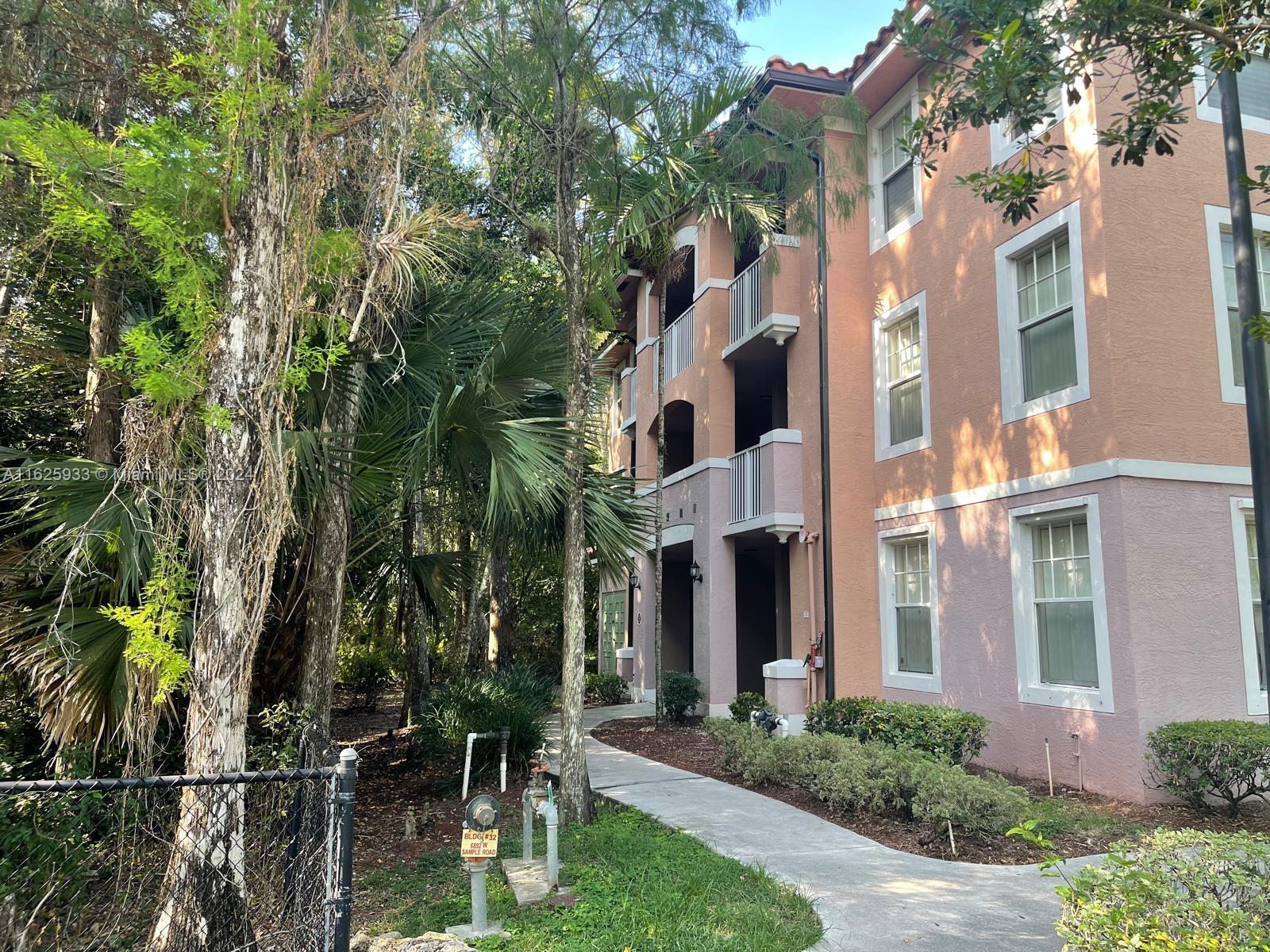6912 West Sample Road, Unit 6912 Pompano Beach, FL 33063 - Photo 4 of 27 a view of multiple house with yard