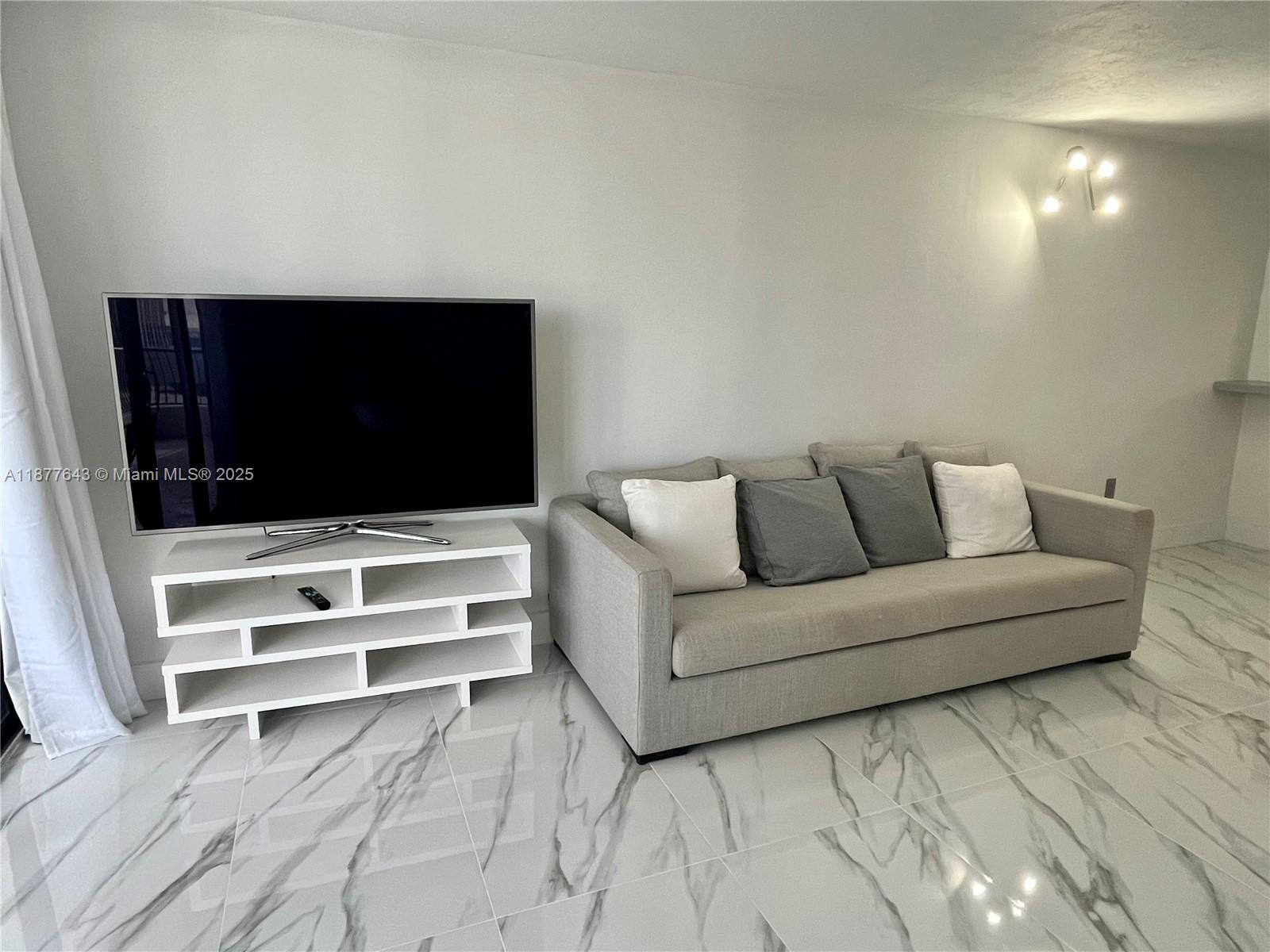 555 Northeast 15th Street, Unit 15G Miami, FL 33132 - Photo 34 of 61 a living room with furniture and a flat screen tv