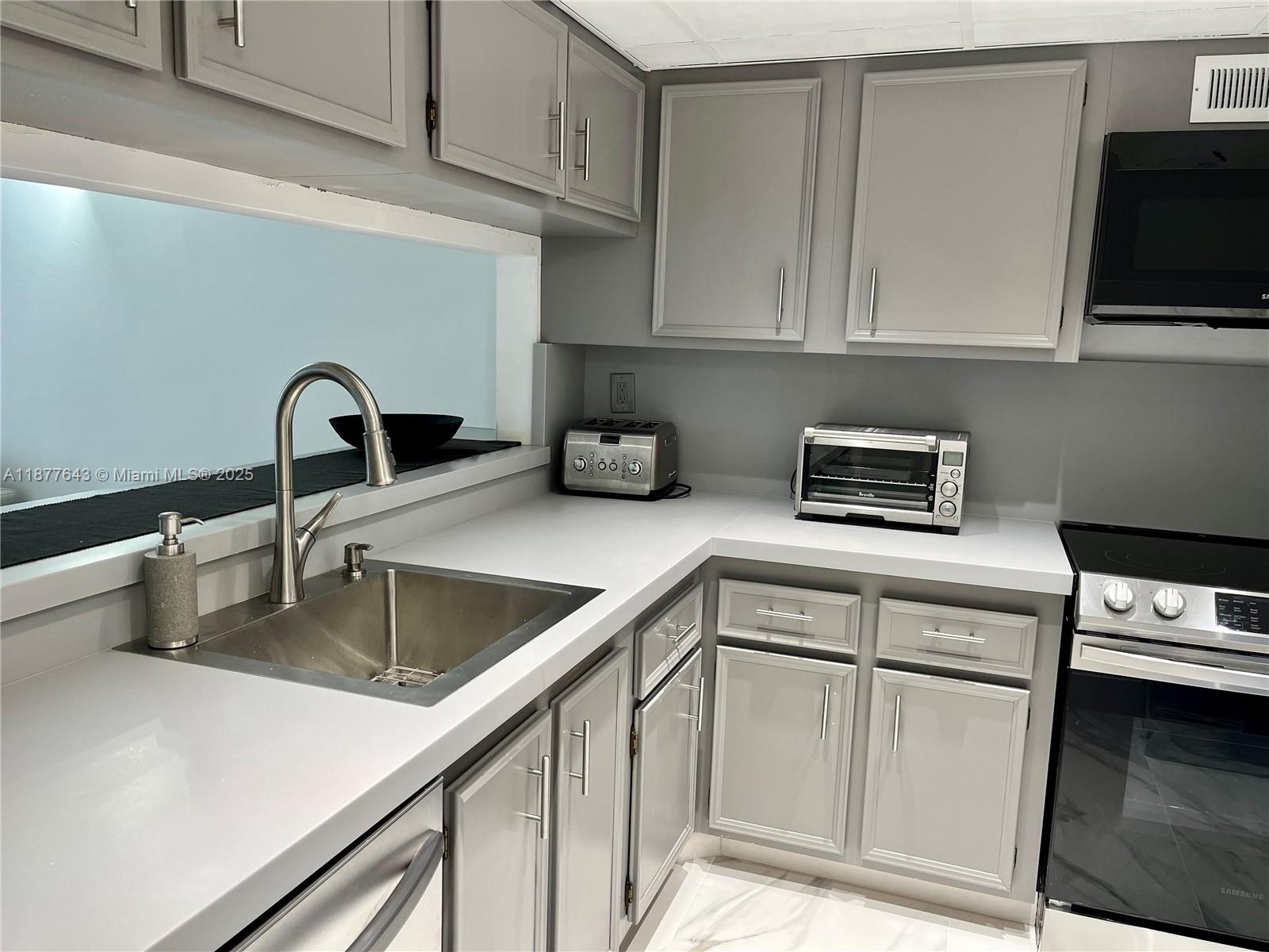 555 Northeast 15th Street, Unit 15G Miami, FL 33132 - Photo 36 of 61 a kitchen with white cabinets and appliances