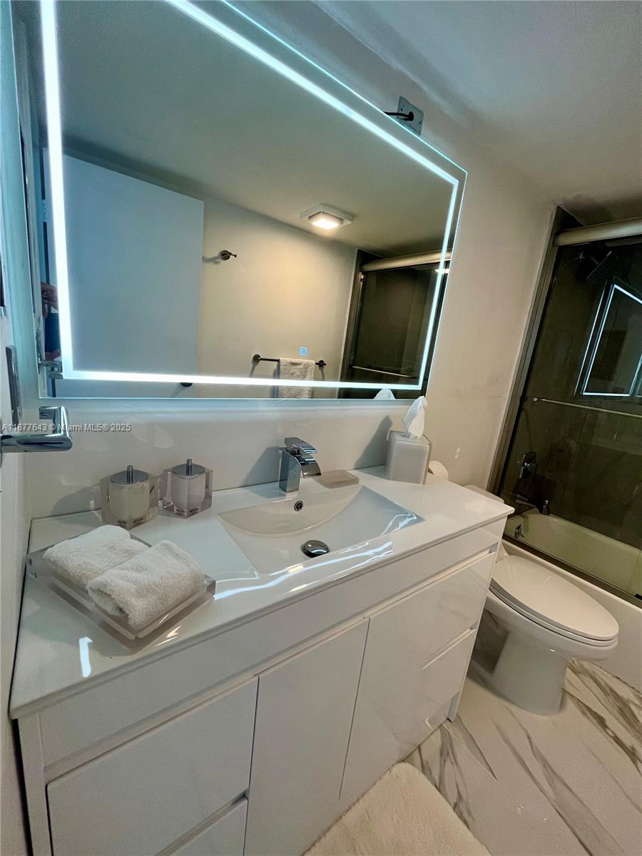 555 Northeast 15th Street, Unit 15G Miami, FL 33132 - Photo 47 of 61 a bathroom with a toilet sink and mirror