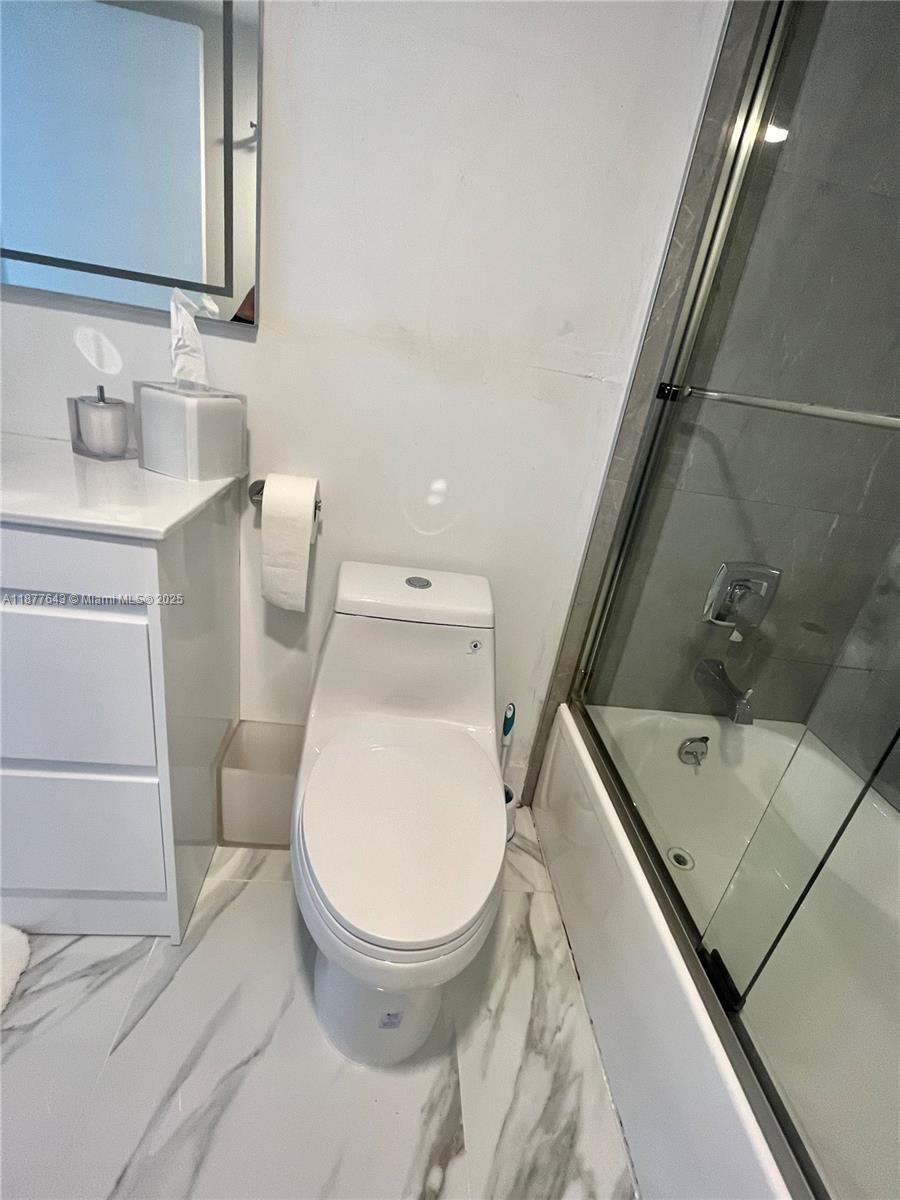 555 Northeast 15th Street, Unit 15G Miami, FL 33132 - Photo 59 of 61 a bathroom with a toilet sink and mirror