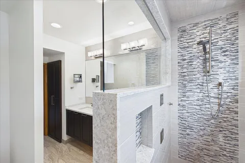 a bathroom with a granite countertop shower a sink and a mirror