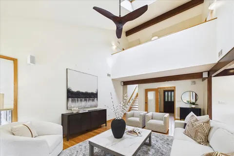 a living room with furniture a flat screen tv and a large window
