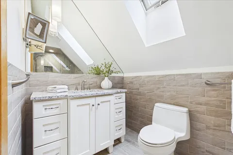 a bathroom with a granite countertop toilet sink and mirror
