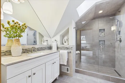 a bathroom with a granite countertop sink a mirror and a shower