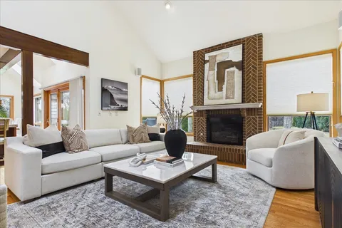 a living room with furniture fireplace and a large window
