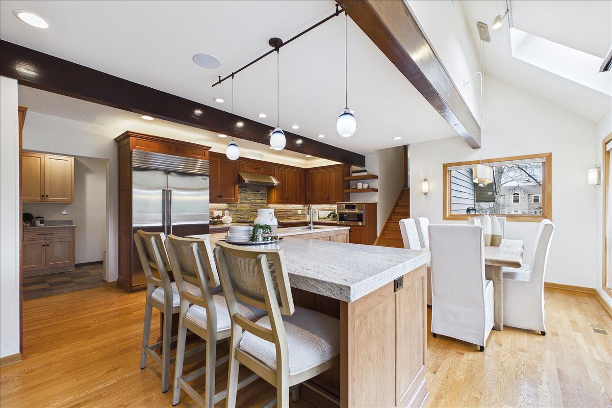 131 West Everett Road Lake Forest, IL 60045 - Photo 6 of 43 a dining room with stainless steel appliances kitchen island granite countertop a table chairs and a wooden floor