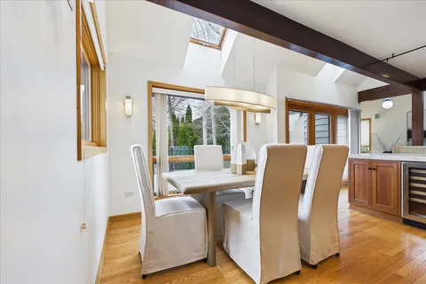 a view of a dining room with furniture wooden floor and a kitchen view