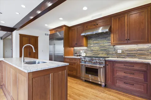 a kitchen with stainless steel appliances granite countertop a stove sink and cabinets