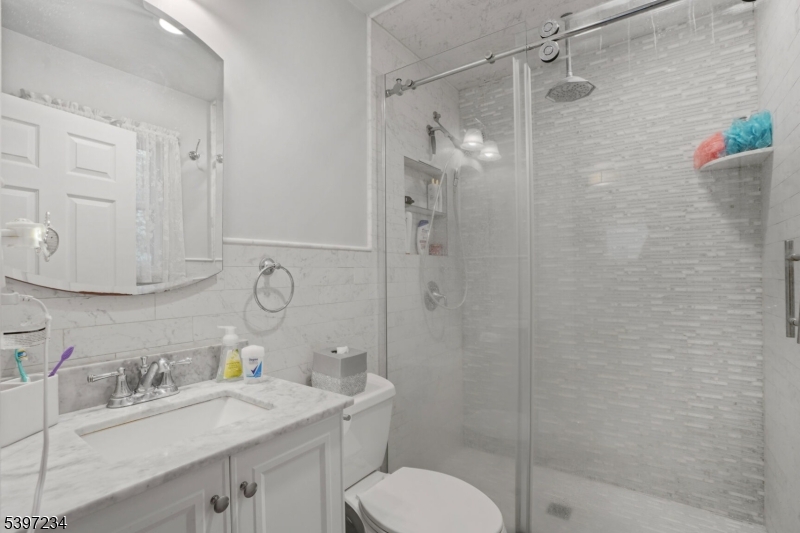 102 East Shore Road Denville, NJ 07834 - Photo 10 of 14 a bathroom with a sink toilet a mirror and shower