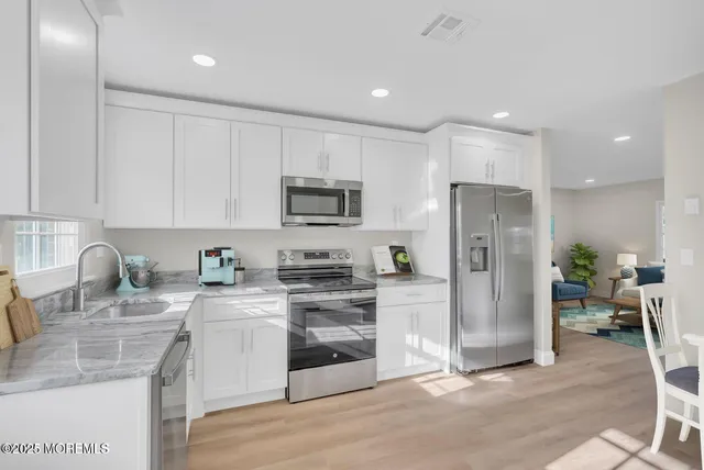 a kitchen with stainless steel appliances granite countertop a refrigerator stove a sink and a granite counter tops