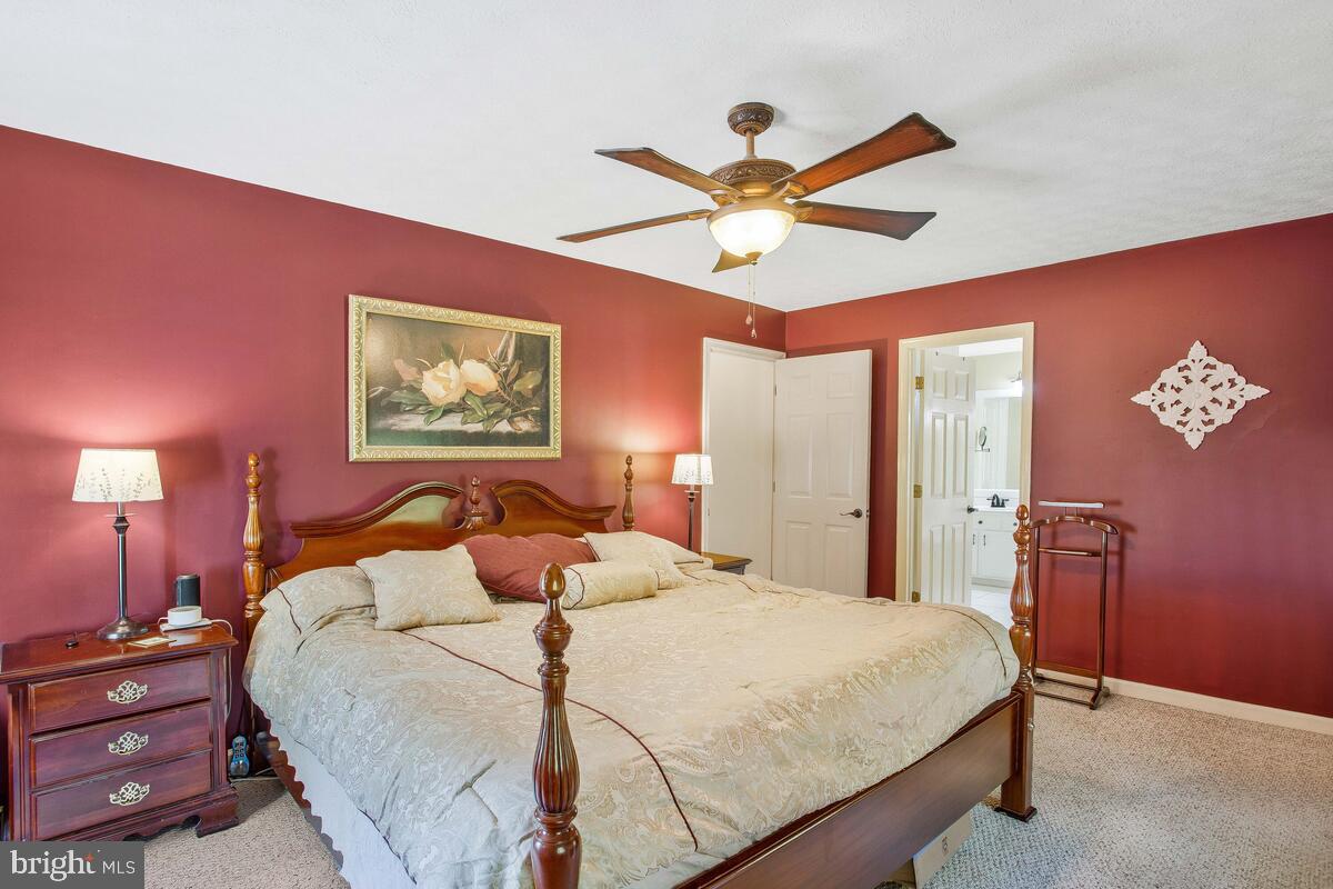 165 Ball Road St. Leonard, MD 20685 - Photo 35 of 55 a bedroom with a large bed and a chandelier