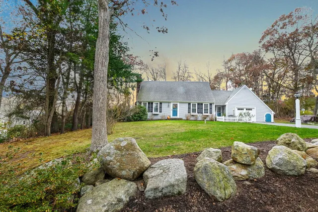 a view of a house with backyard and a tree