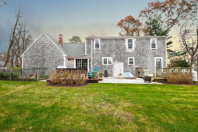 a view of a house with a big yard and a large tree front of the house
