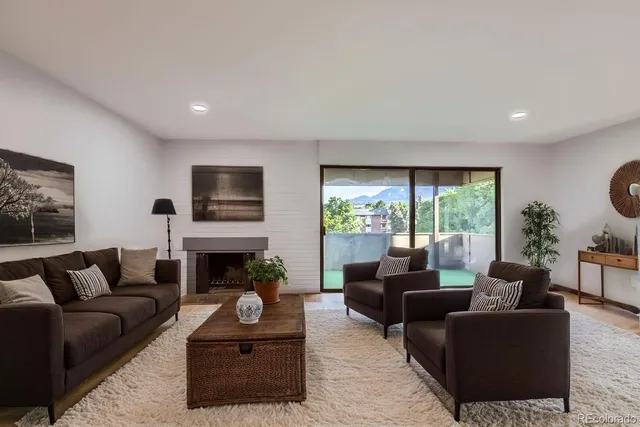 a living room with furniture a large window and a fireplace