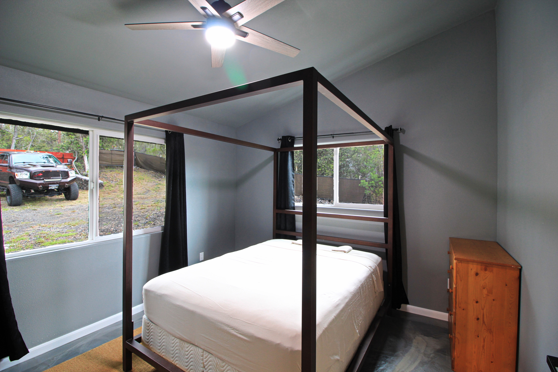 92-1920 Aloha Boulevard Ocean View, HI 96704 - Photo 20 of 26 a bedroom with a bed and large window with balcony view