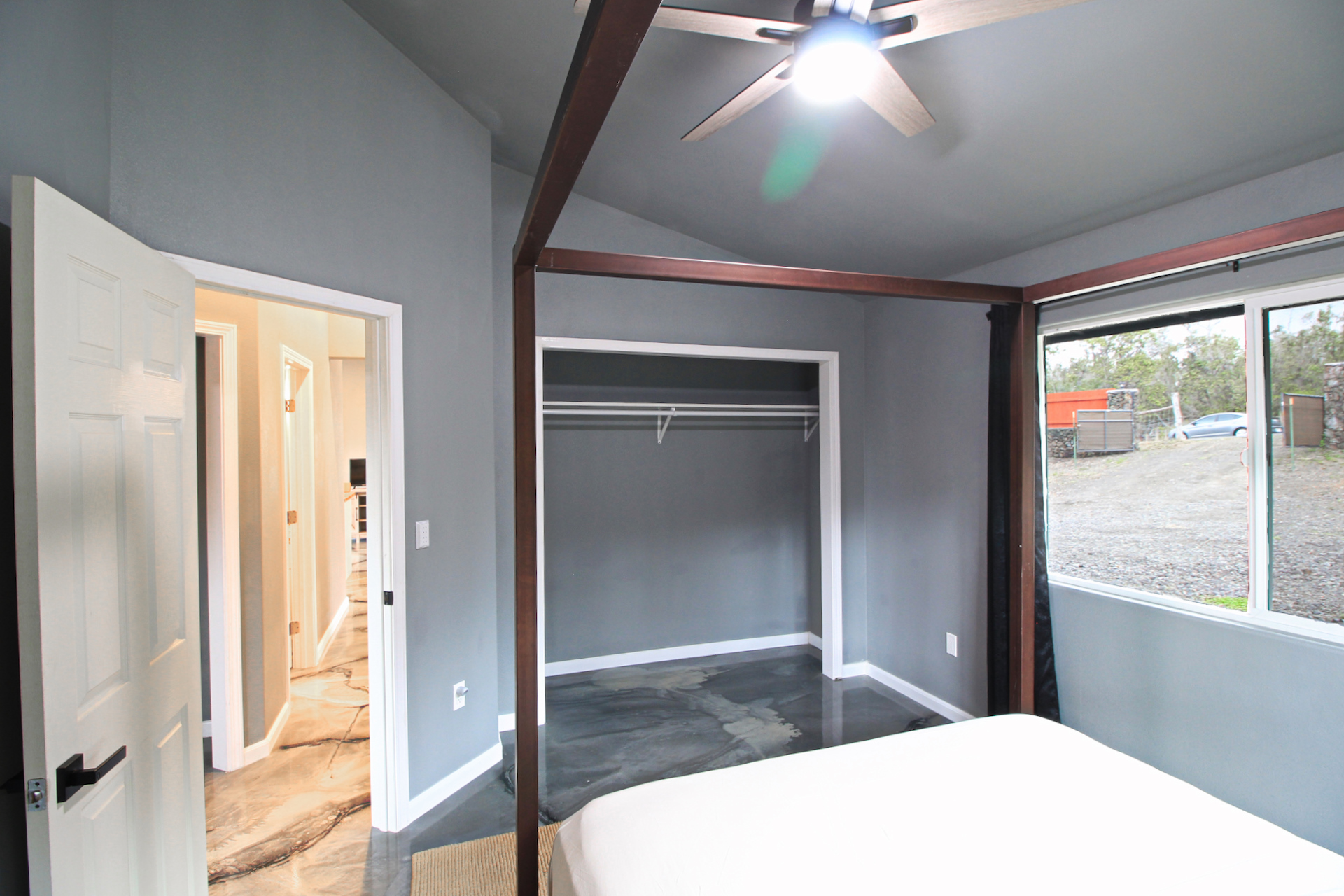 92-1920 Aloha Boulevard Ocean View, HI 96704 - Photo 21 of 26 a bedroom with a bed and a large window with outer view