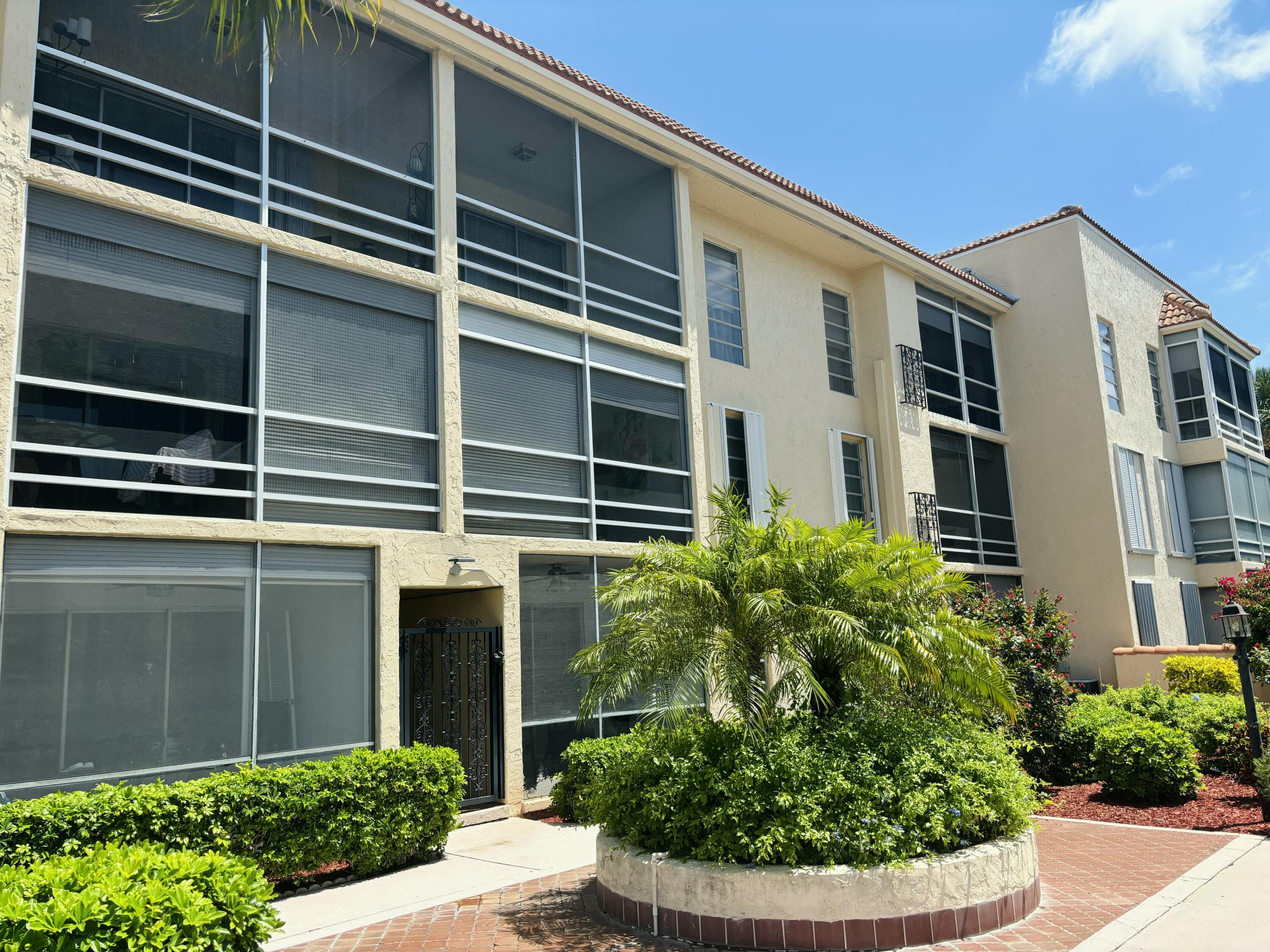 331 Southwest 8th Street, Unit 2CE Boca Raton, FL 33432 - Photo 16 of 19 a front view of a house with plants